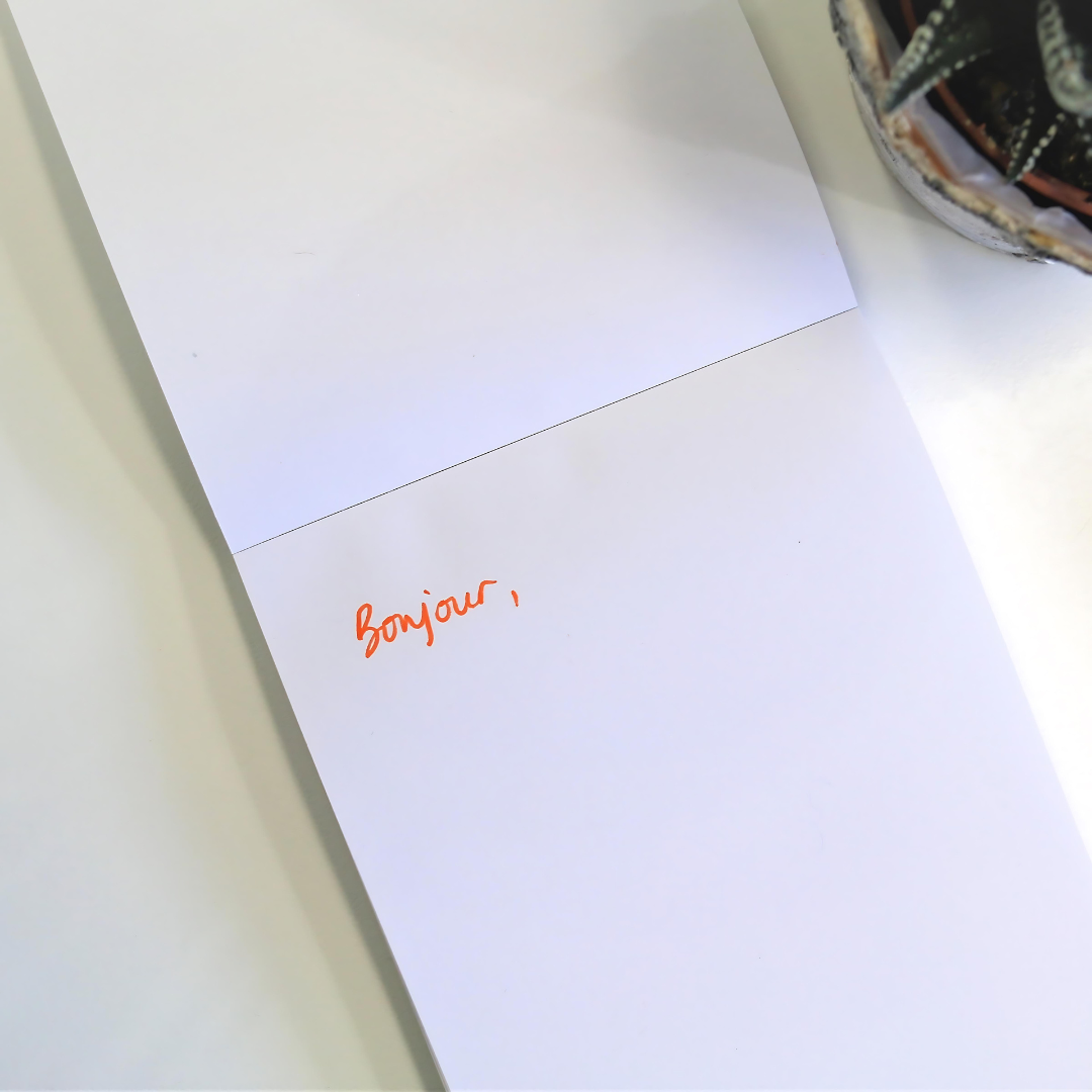 Bloc-notes solidaire et fait de papier recyclé Bloc-notes ouvert avec écrit bonjour.