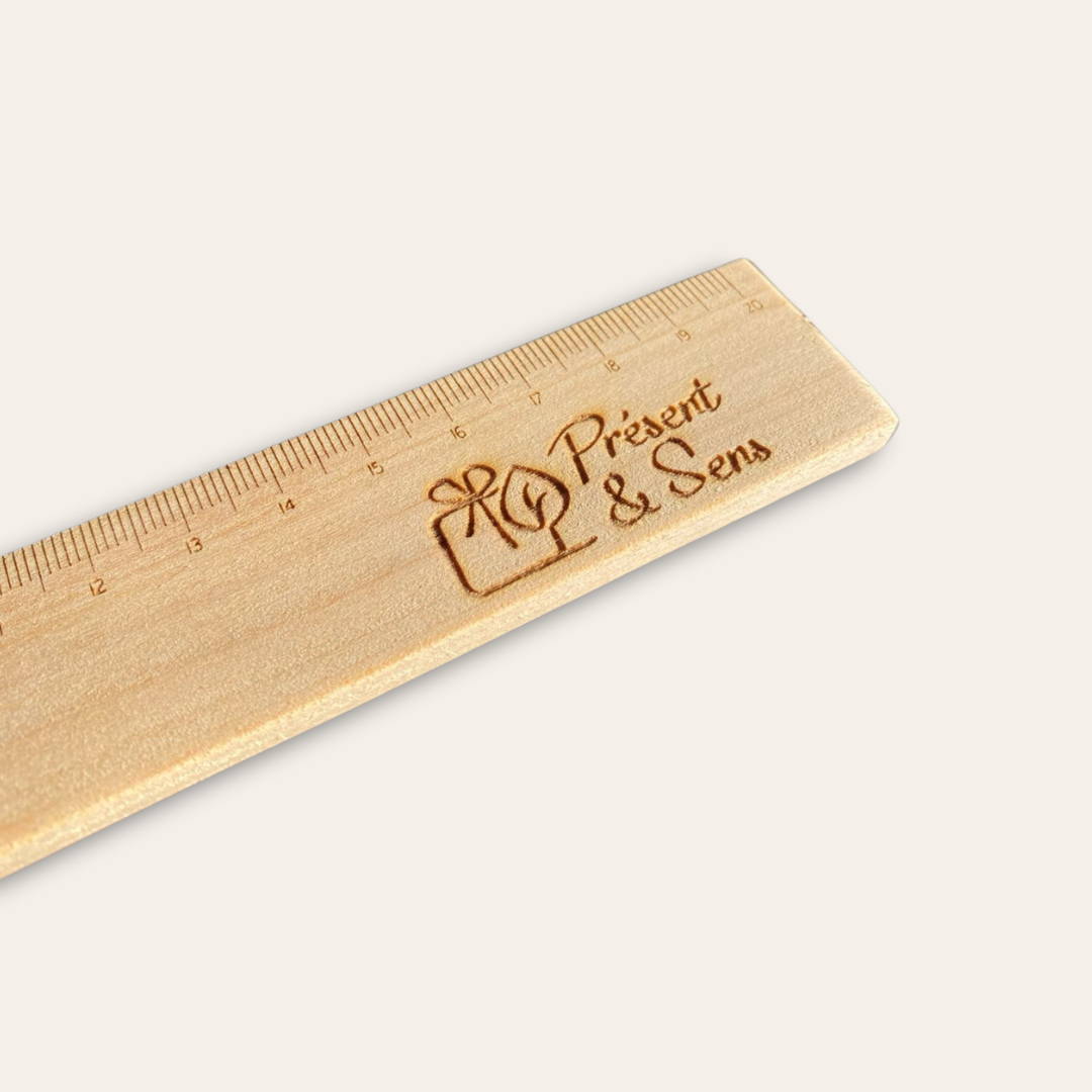 Zoom sur la règle et sa gravure de Présent et Sens Zoom sur la gravure de la règle en bois gravée.