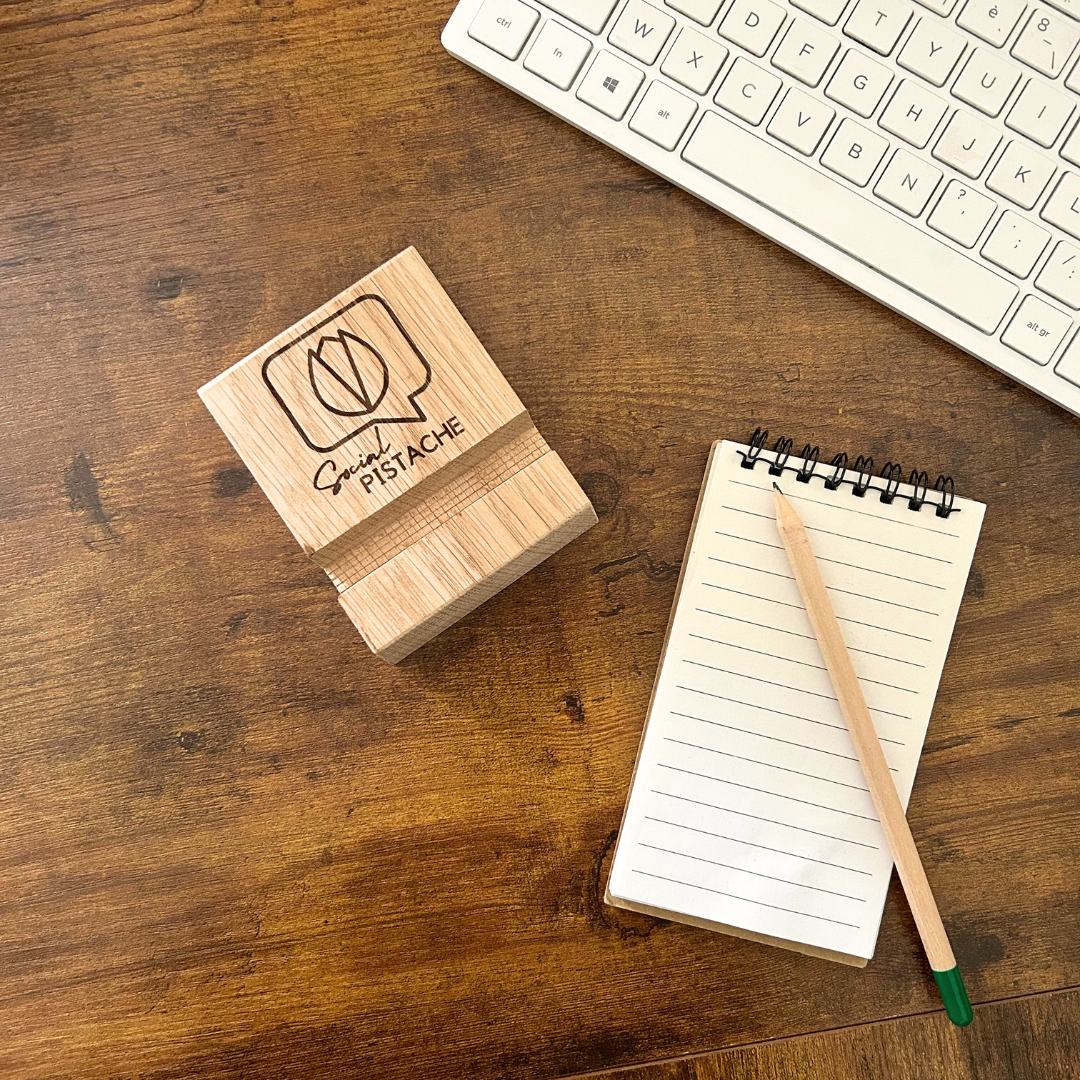 Support téléphone d'un bois personnalisable Support de téléphone en bois gravé d'un logo avec un bloc-notes en papier puis d'un clavier sur le côté.