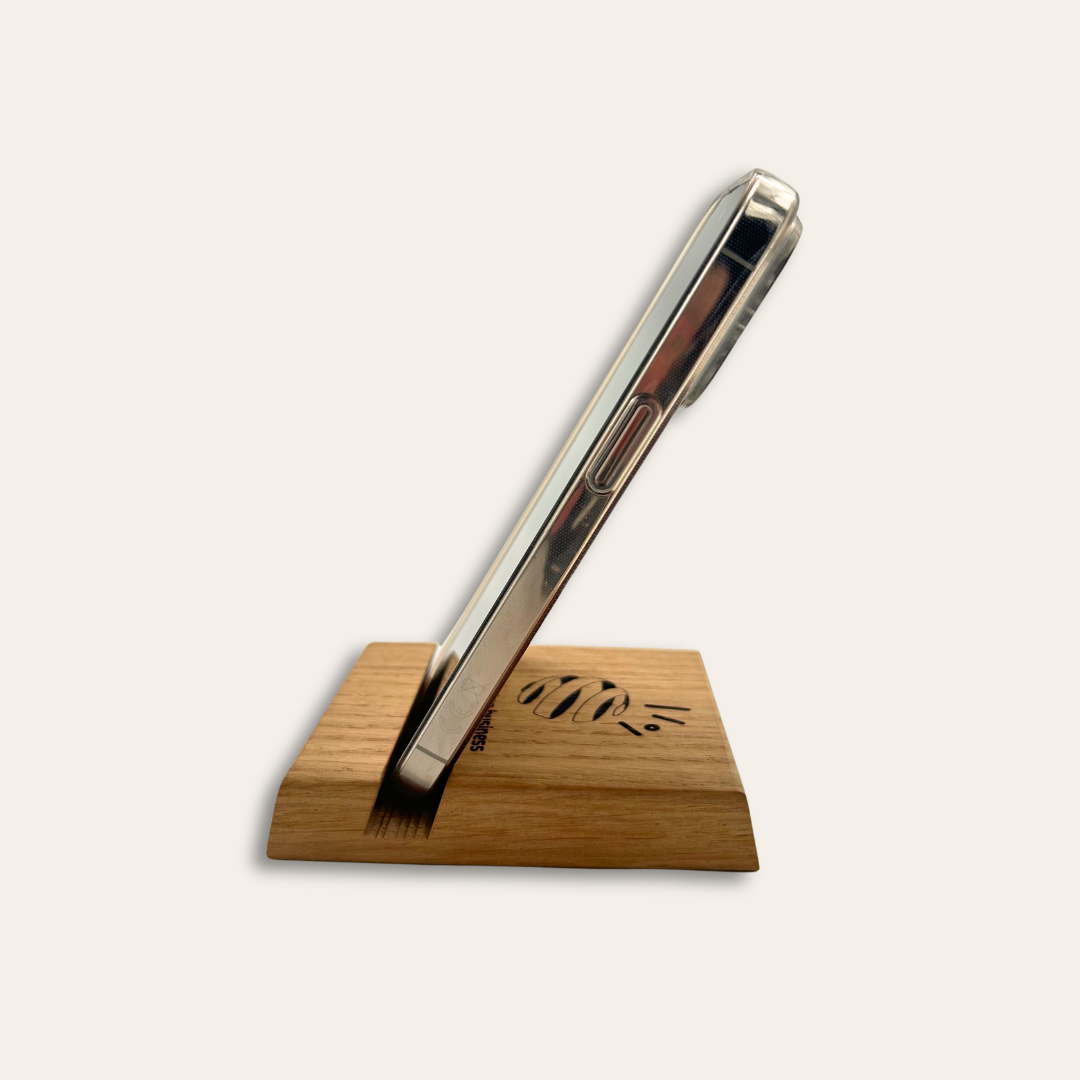 Support téléphone bois gravé sur le côté Support de téléphone en bois gravé mis sur le côté avec un mobile dessus.