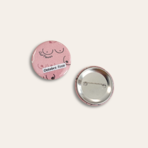 Rond coloris rose avec illustrations des seins et un rond avec broche.