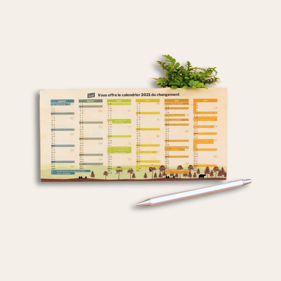 Calendrier en bois made in France Petit calendrier en bois avec une plante en arrière-plan et un stylo en premier-plan.