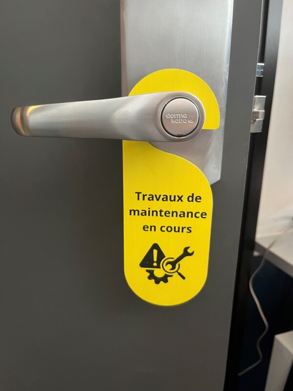 accroche porte jaune chambre hotel pour maintenance intervention
