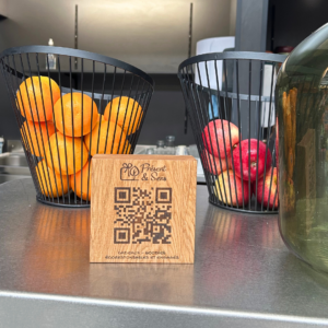 Cube avec un QR code dessus, posé sur un bar avec des fruits en arrière-plan.