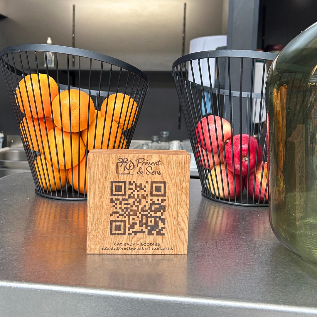 Cube QR Code pulicitaire Cube avec un QR code dessus, posé sur un bar avec des fruits en arrière-plan.