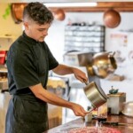 homme qui tient une casserole et qui verse du sucre liquide dans confiserie artisanale berlingots