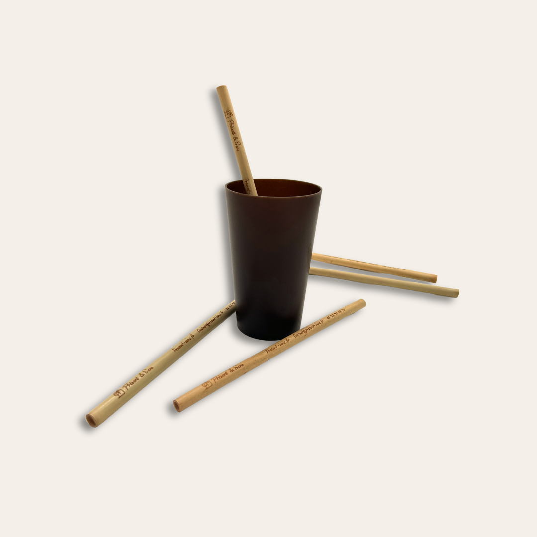 Paille en bambou à personnalisée Des pailles en bambou et une paille dans le verre.