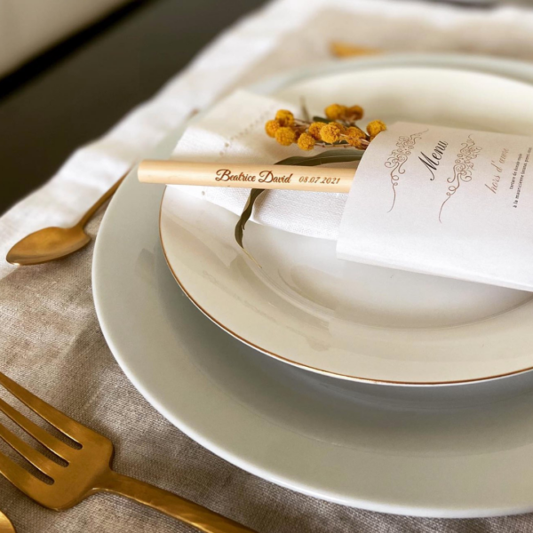 Paille dans un étui et posés sur des assiettes de mariage.