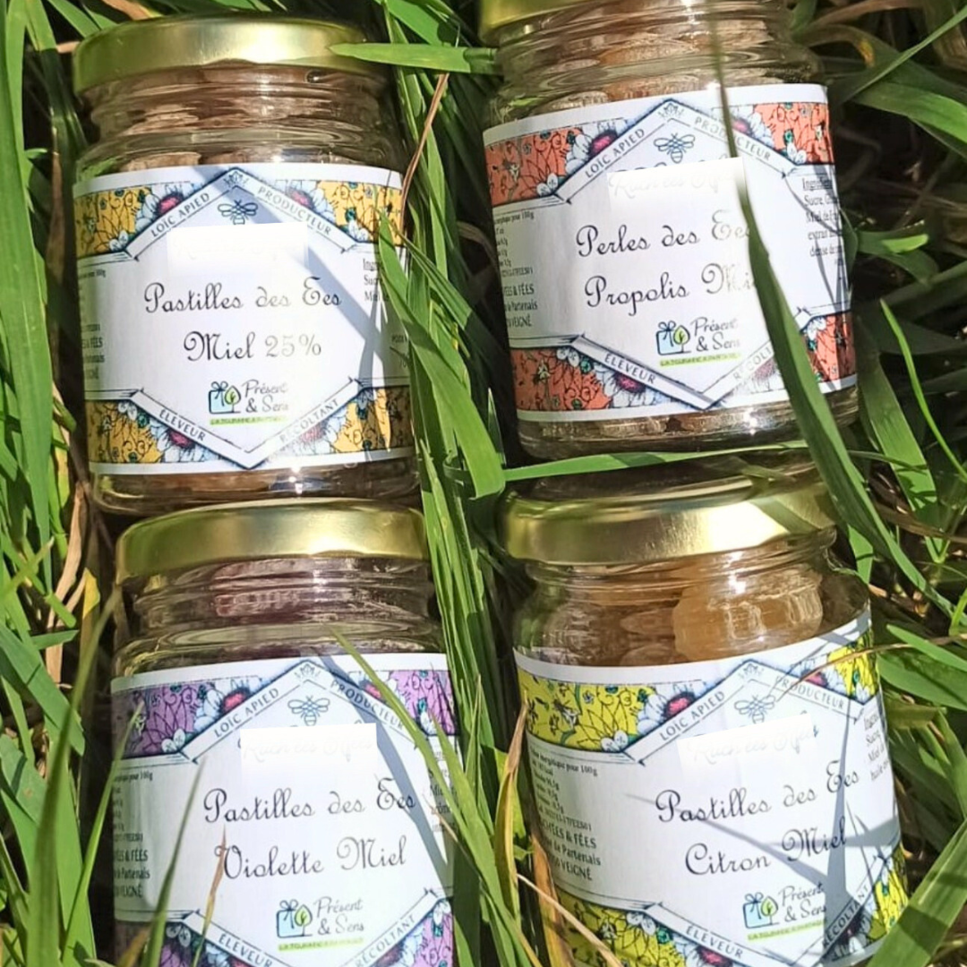 Pastilles au miel Pots de pastilles posés sur de l'herbe.