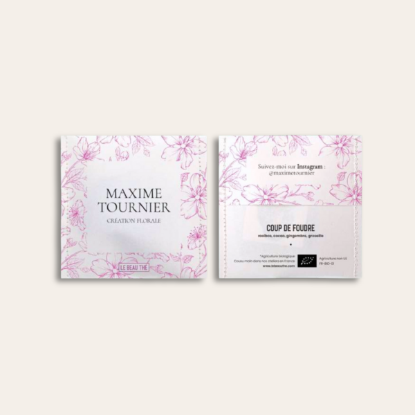 Sachet de thé coloris blanc en recto verso avec des illustrations de fleurs rose et du texte ecrit dessus.