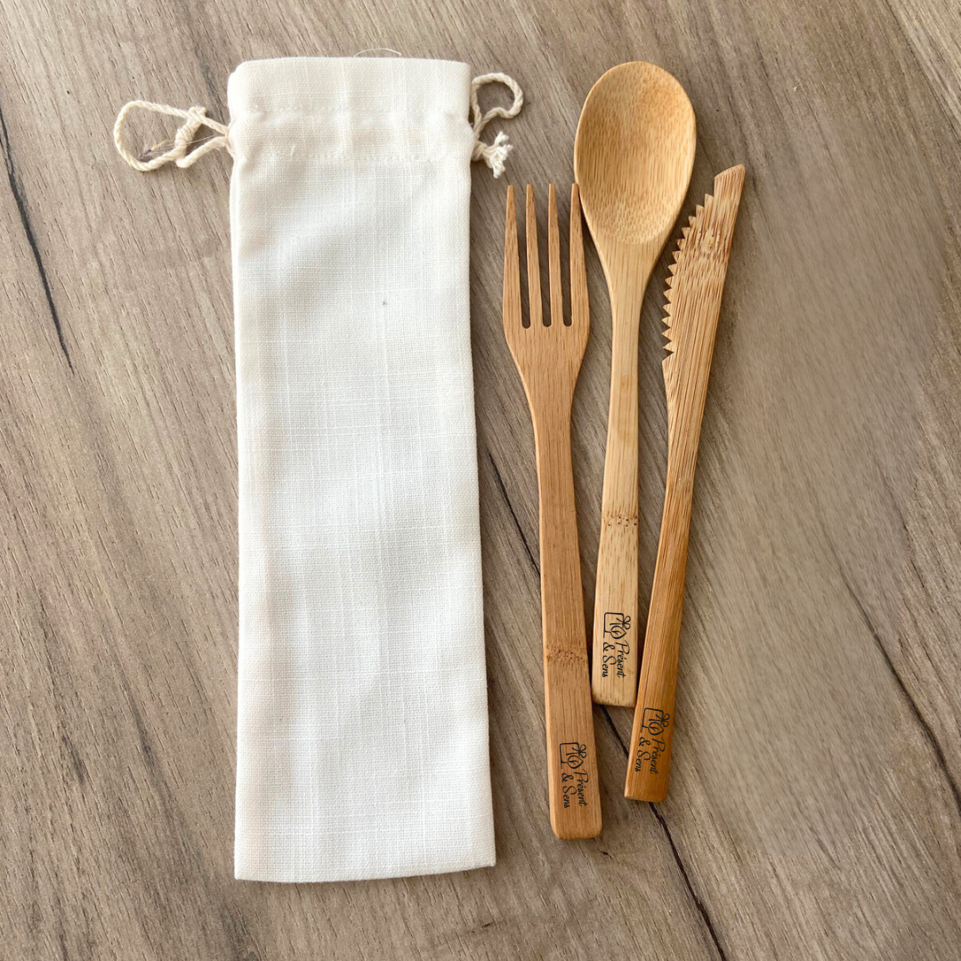 Set couverts en bambou à personnaliser Des couverts en bois, accompagnés d'un étui et posés sur du bois.