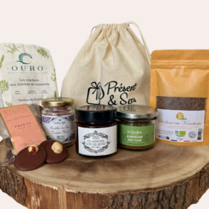 coffret sur rondin de bois avec crackers, palets noisette, confiture, pastille miel violette, sel fumé, tartinade aubergine, confiture et pochon